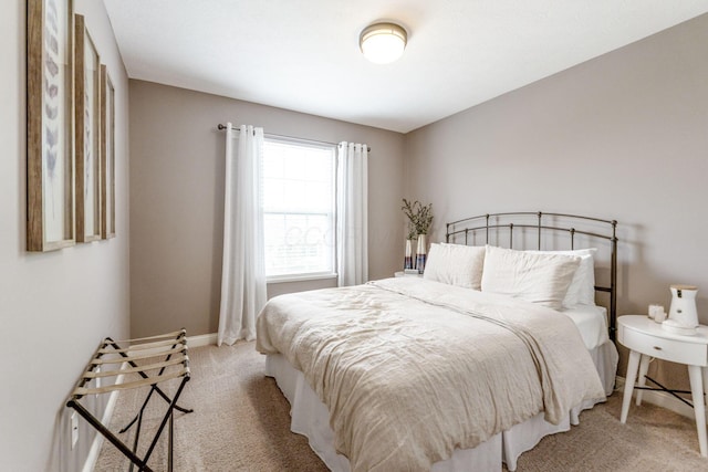 bedroom featuring baseboards and light colored carpet
