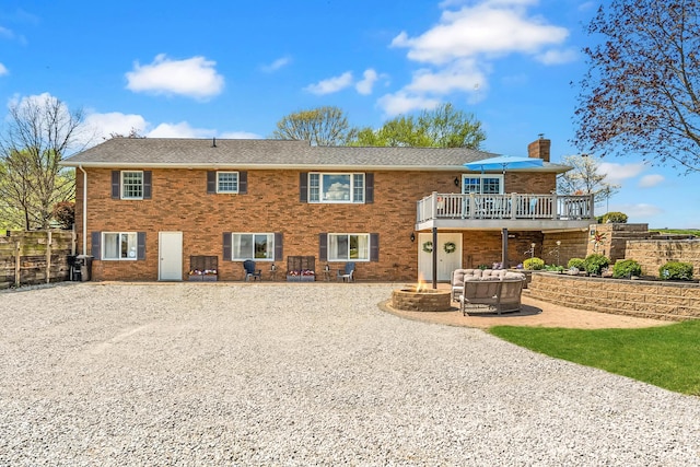 1012 Lake Fork Rd, Utica, OH 43080 - rear view of property featuring a wooden deck, a chimney, brick siding, a patio area, and an outdoor fire pit