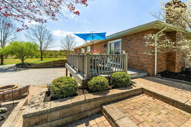 1012 Lake Fork Rd, Utica, OH 43080 - view of side of property with a wooden deck, a chimney, a patio area, and brick siding