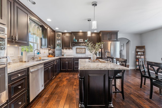 1012 Lake Fork Rd, Utica, OH 43080 - kitchen featuring a breakfast bar, dark brown cabinets, arched walkways, a sink, and stainless steel appliances
