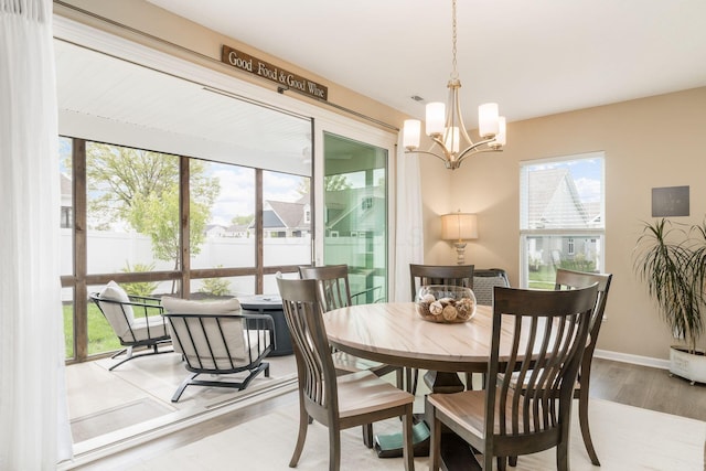dining room featuring an inviting chandelier, baseboards, and wood finished floors