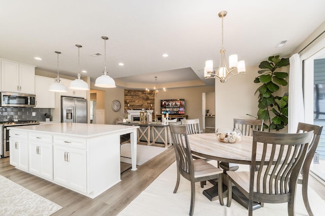 dining space with a chandelier, light wood-style flooring, visible vents, and recessed lighting