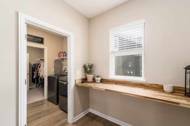 interior space featuring dark wood-style flooring, baseboards, and washer and dryer