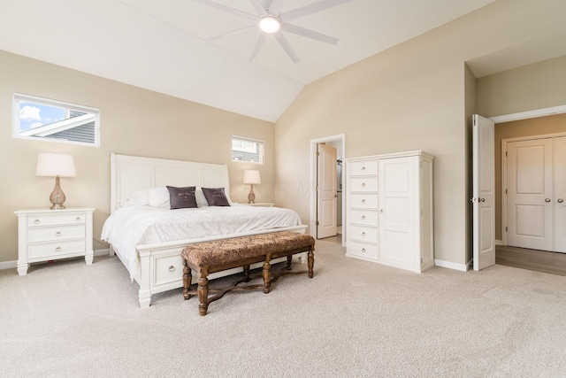 bedroom featuring light carpet, baseboards, a ceiling fan, and high vaulted ceiling