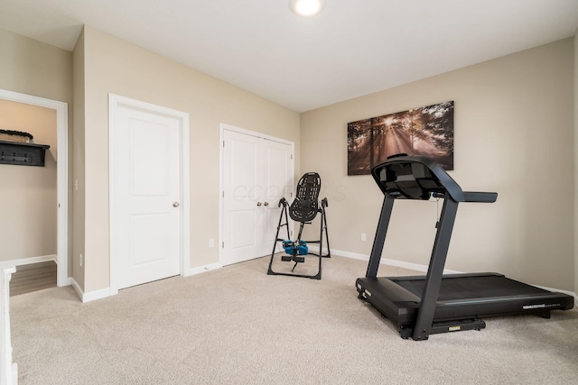 workout area featuring baseboards and carpet floors