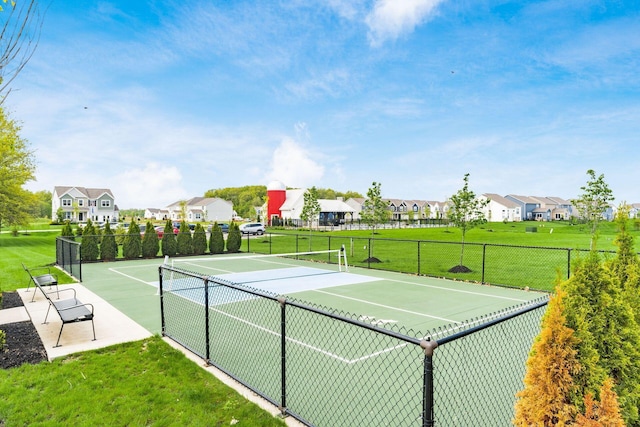 view of sport court featuring a lawn, a residential view, and fence