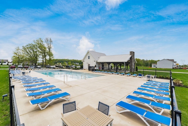 pool with a patio area and fence