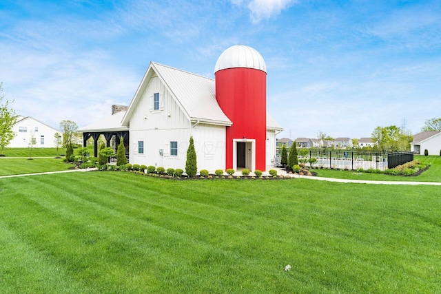 exterior space with a yard, fence, metal roof, and board and batten siding