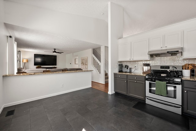 1479 Brookforest Dr, Columbus, OH 43204 - kitchen with decorative backsplash, gray cabinets, under cabinet range hood, and stainless steel gas stove
