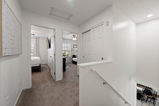 1479 Brookforest Dr, Columbus, OH 43204 - hallway featuring baseboards, attic access, a textured ceiling, carpet flooring, and an upstairs landing