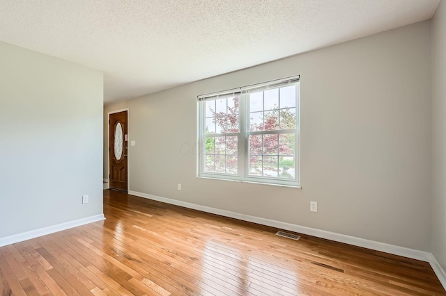 3861 Trestle Ct, Columbus, OH 43204 - spare room with light wood-style flooring, baseboards, and a textured ceiling