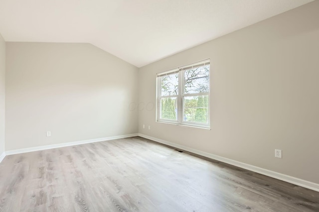 3861 Trestle Ct, Columbus, OH 43204 - empty room featuring wood finished floors, vaulted ceiling, and baseboards