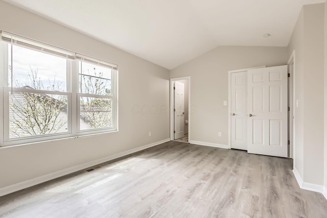 3861 Trestle Ct, Columbus, OH 43204 - unfurnished bedroom featuring light wood-style floors, vaulted ceiling, and baseboards