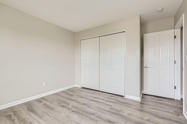 3861 Trestle Ct, Columbus, OH 43204 - unfurnished bedroom featuring light wood-style floors, a closet, and baseboards