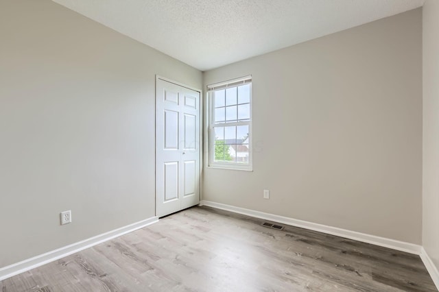 3861 Trestle Ct, Columbus, OH 43204 - unfurnished bedroom with wood finished floors, baseboards, a closet, and a textured ceiling