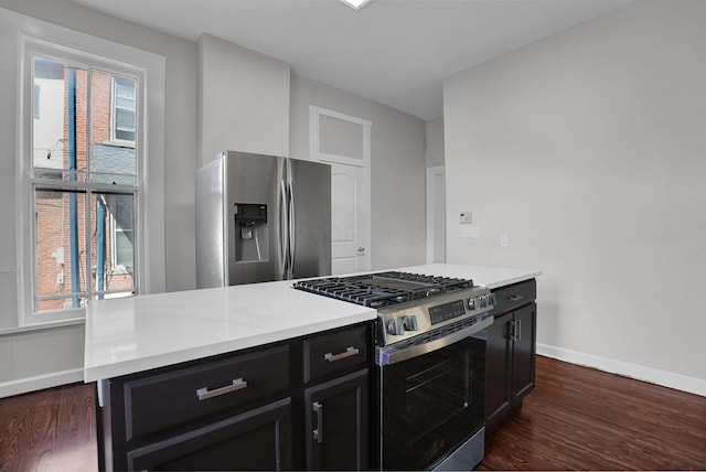 kitchen with baseboards, dark wood-type flooring, light countertops, dark cabinetry, and stainless steel appliances