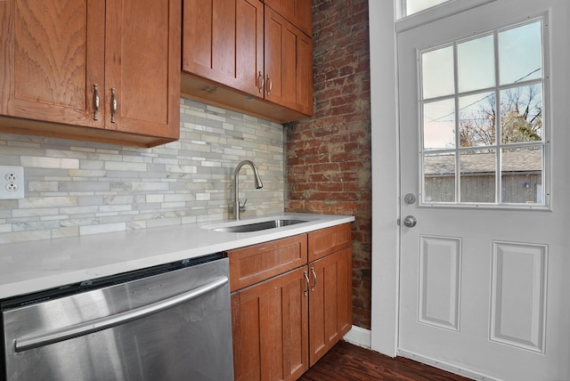 kitchen featuring stainless steel dishwasher, decorative backsplash, light countertops, brown cabinets, and a sink