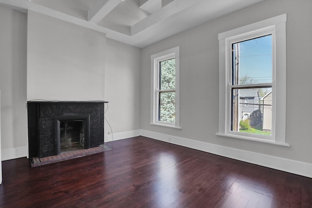 unfurnished living room featuring a fireplace with flush hearth, baseboards, and wood finished floors