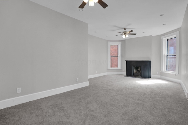 unfurnished living room with baseboards, a ceiling fan, and carpet flooring