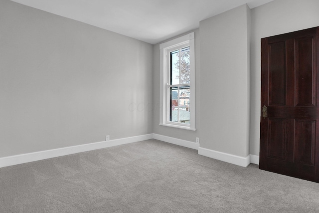 empty room featuring baseboards and carpet flooring