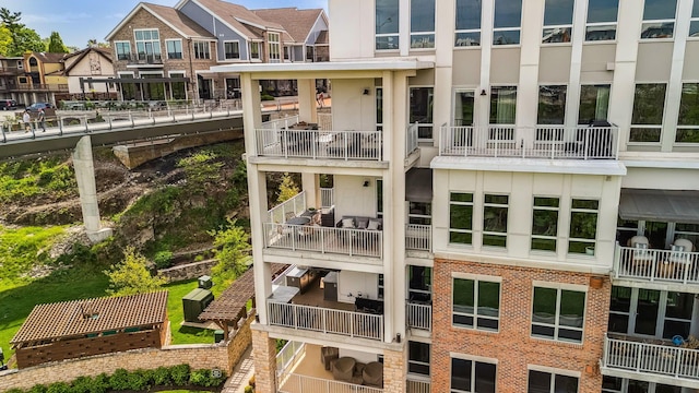 rear view of property with a balcony and brick siding