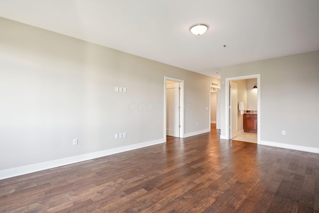 unfurnished room with dark wood finished floors and baseboards