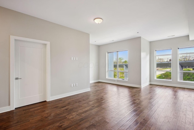 empty room featuring dark wood-style flooring and baseboards