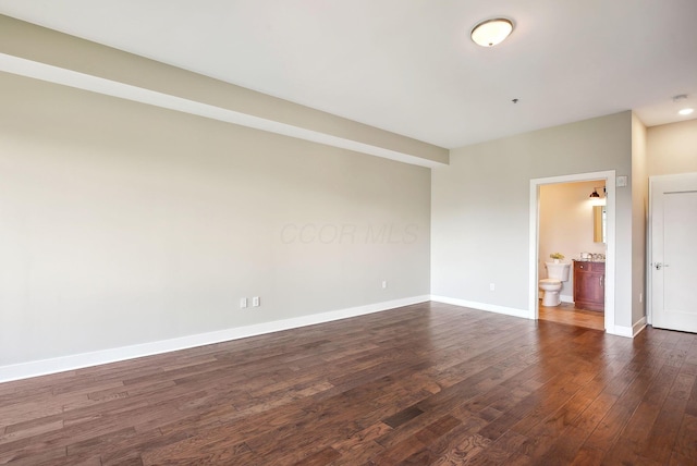 empty room with dark wood-style floors and baseboards