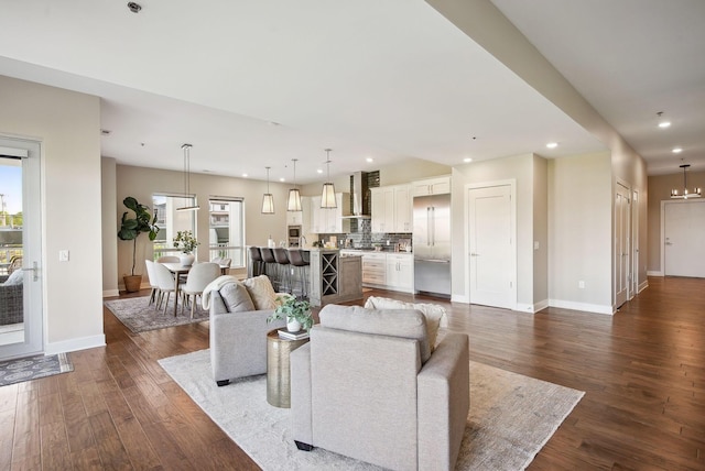 living area featuring dark wood-type flooring, baseboards, and recessed lighting
