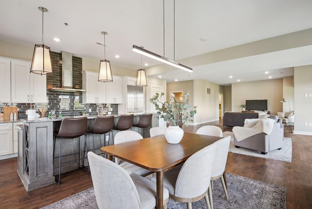 dining room featuring baseboards, dark wood finished floors, and recessed lighting