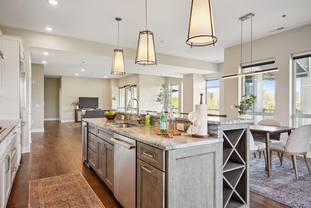 kitchen with a sink, stainless steel dishwasher, dark wood finished floors, open shelves, and a spacious island