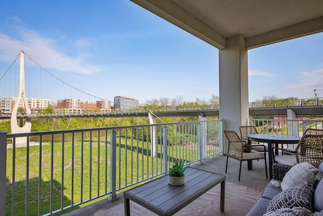 balcony with outdoor dining area and a view of city