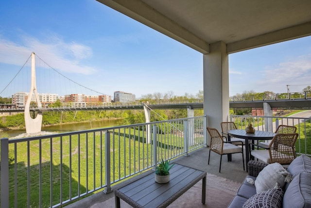 balcony featuring a water view and outdoor dining space