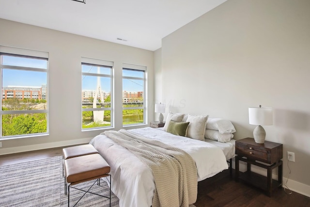 bedroom featuring baseboards and dark wood-style flooring