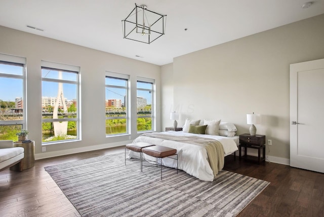 bedroom featuring dark wood finished floors, baseboards, and a chandelier