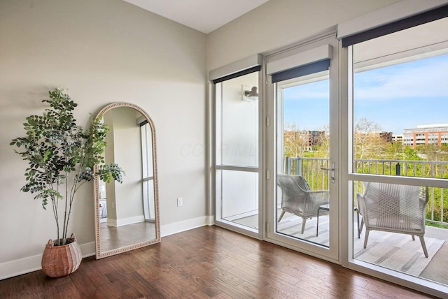 doorway featuring dark wood finished floors and baseboards