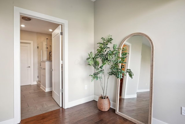 hallway with wood finished floors, baseboards, and recessed lighting
