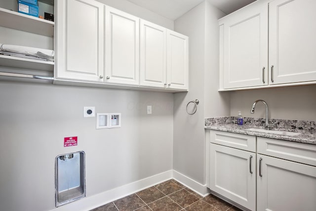 clothes washing area with washer hookup, baseboards, electric dryer hookup, cabinet space, and dark tile patterned floors