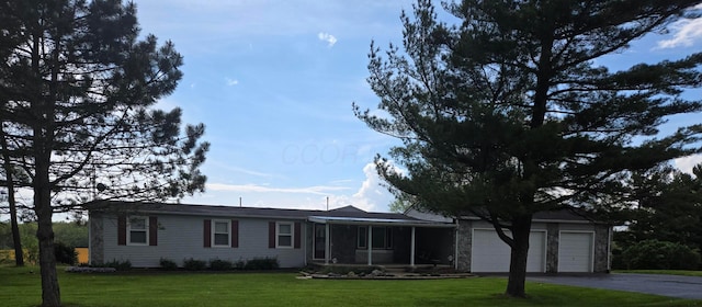 view of front of property featuring an attached garage, a front lawn, and driveway