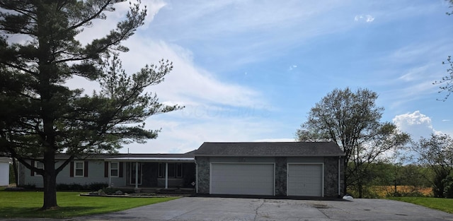 ranch-style home with covered porch, driveway, a front lawn, an attached garage, and stone siding
