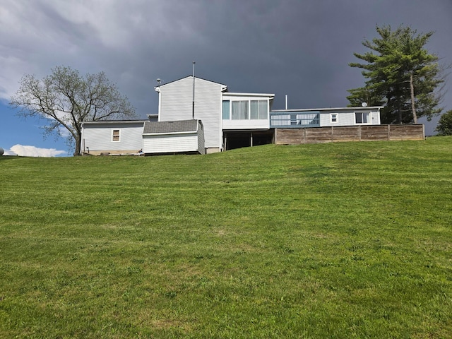 rear view of property featuring a sunroom and a yard