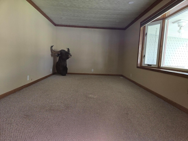 spare room with baseboards, ornamental molding, and light carpet