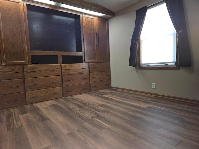 unfurnished bedroom featuring baseboards and dark wood-style floors