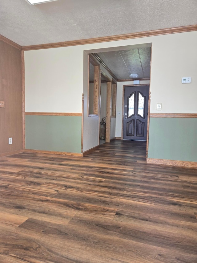 entryway with crown molding, dark wood-style floors, and a textured ceiling