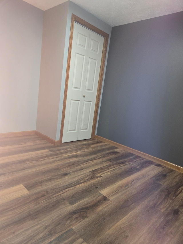 unfurnished bedroom with baseboards and wood finished floors