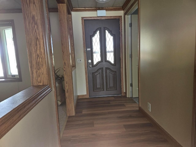 entryway with baseboards, dark wood finished floors, and ornamental molding