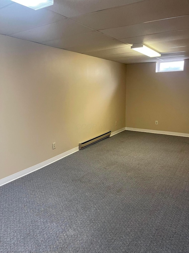 10519 Darby Creek Rd, Orient, OH 43146 - empty room with a baseboard radiator, dark colored carpet, baseboards, and a paneled ceiling