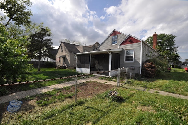 view of front of property with fence, a chimney, a sunroom, and a front lawn