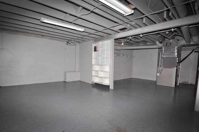 below grade area with heating unit and concrete block wall