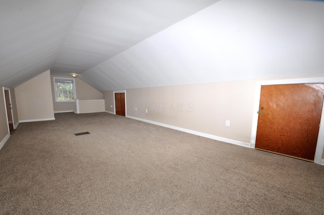 additional living space featuring carpet floors, baseboards, vaulted ceiling, and visible vents